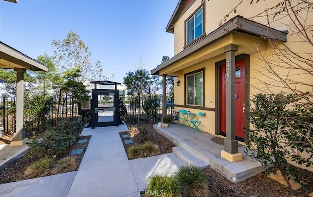 exterior space featuring a gate, fence, and stucco siding