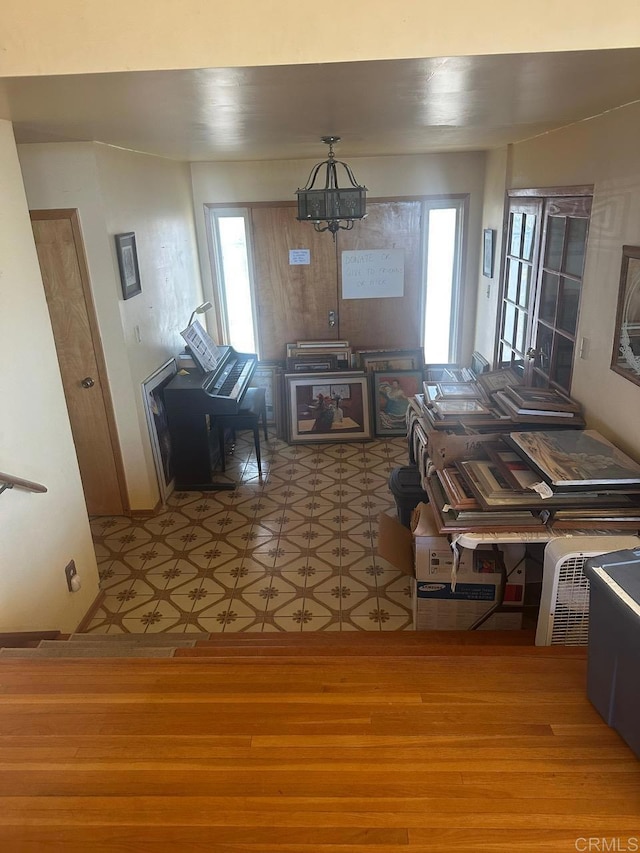 unfurnished living room with a chandelier and wood finished floors