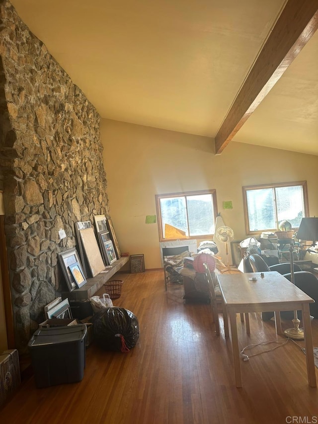 living room with vaulted ceiling with beams, a wealth of natural light, and wood finished floors