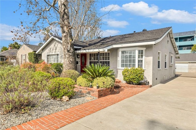 bungalow featuring concrete driveway and stucco siding