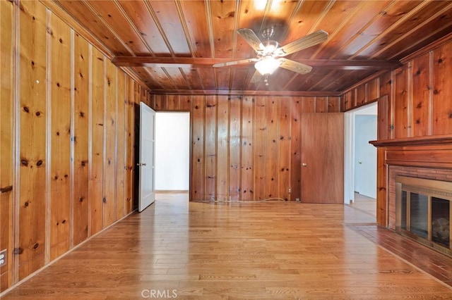 unfurnished living room featuring wood walls, wood ceiling, and light wood-style flooring