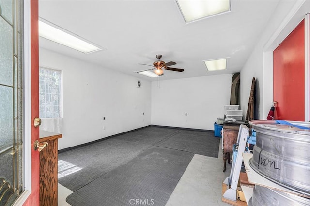 spare room with a ceiling fan and baseboards