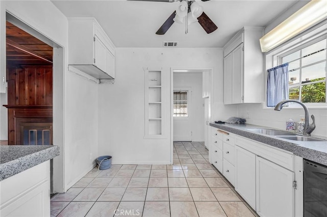 kitchen featuring black dishwasher, visible vents, a sink, and white cabinetry