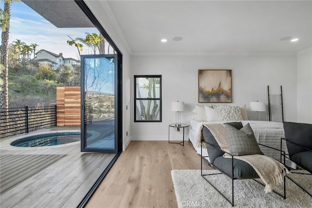 doorway to outside with ornamental molding, light wood-type flooring, recessed lighting, and baseboards