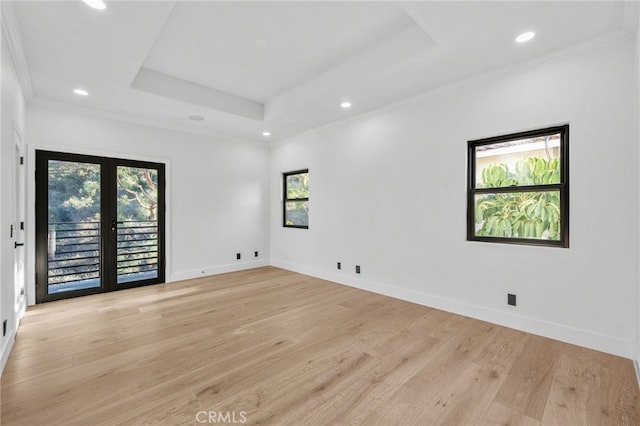 unfurnished room with french doors, a raised ceiling, light wood-style flooring, and baseboards