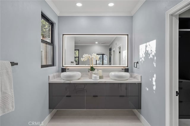 full bathroom with double vanity, a sink, and crown molding