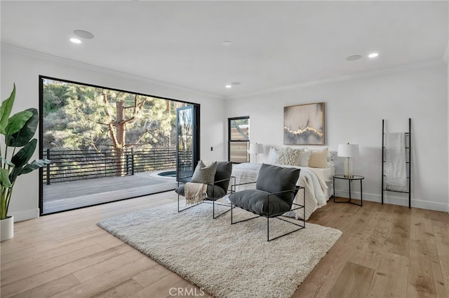 bedroom featuring light wood-type flooring, access to exterior, multiple windows, and ornamental molding