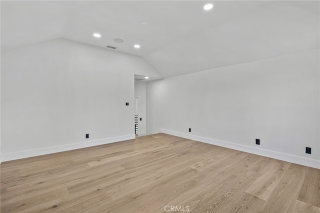 bonus room with light wood-style floors, lofted ceiling, visible vents, and baseboards