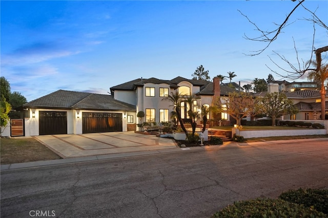 view of front facade featuring a garage, driveway, and stucco siding