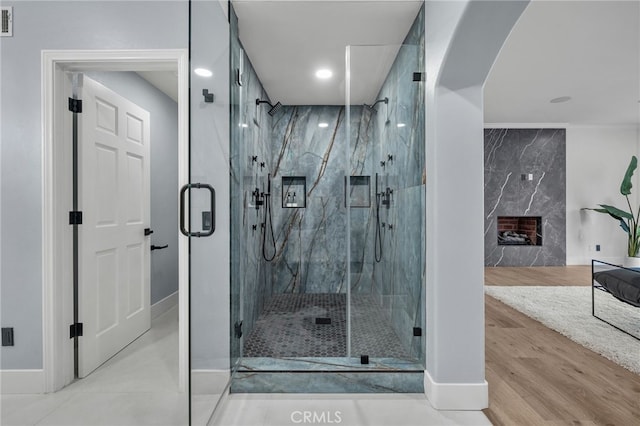 full bath featuring visible vents, a premium fireplace, wood finished floors, and a marble finish shower