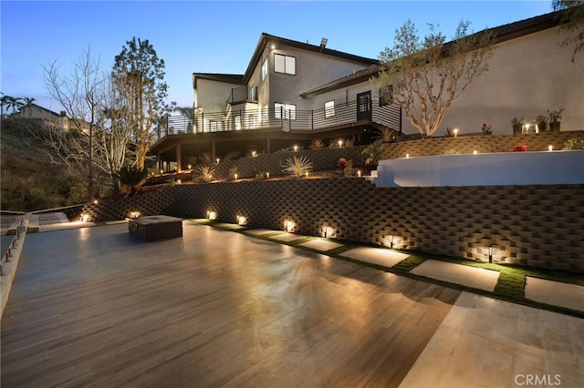 deck at dusk featuring a patio area