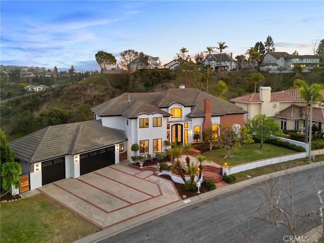 view of front of property featuring a front lawn, a residential view, driveway, and an attached garage