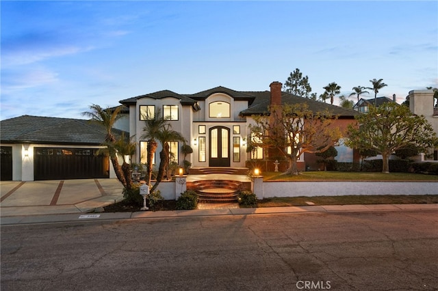 view of front of property with a garage, driveway, and stucco siding