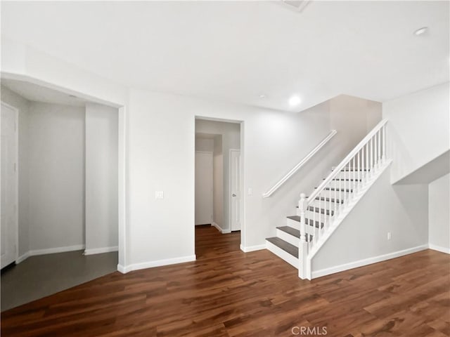 interior space with baseboards, wood finished floors, and recessed lighting