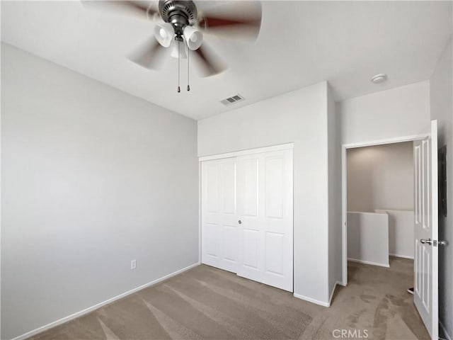 unfurnished bedroom featuring baseboards, visible vents, a closet, and carpet