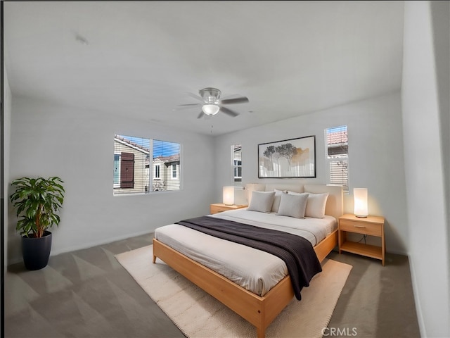 bedroom with a ceiling fan, multiple windows, and carpet