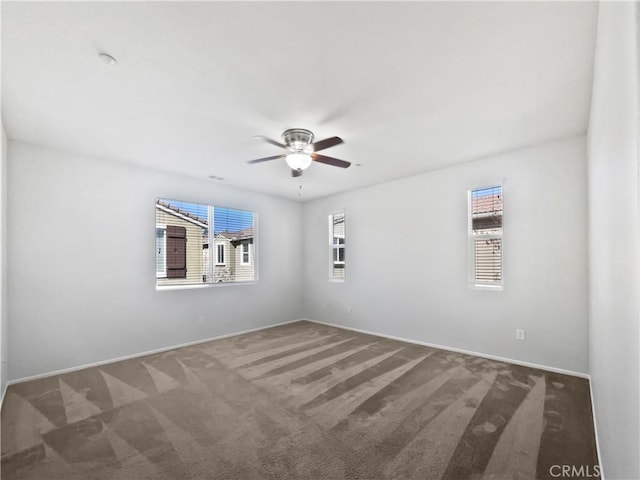 carpeted empty room featuring a ceiling fan