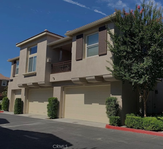 view of property featuring an attached garage and stucco siding