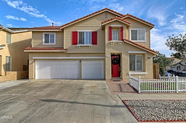 view of front facade featuring an attached garage, concrete driveway, a tile roof, and fence