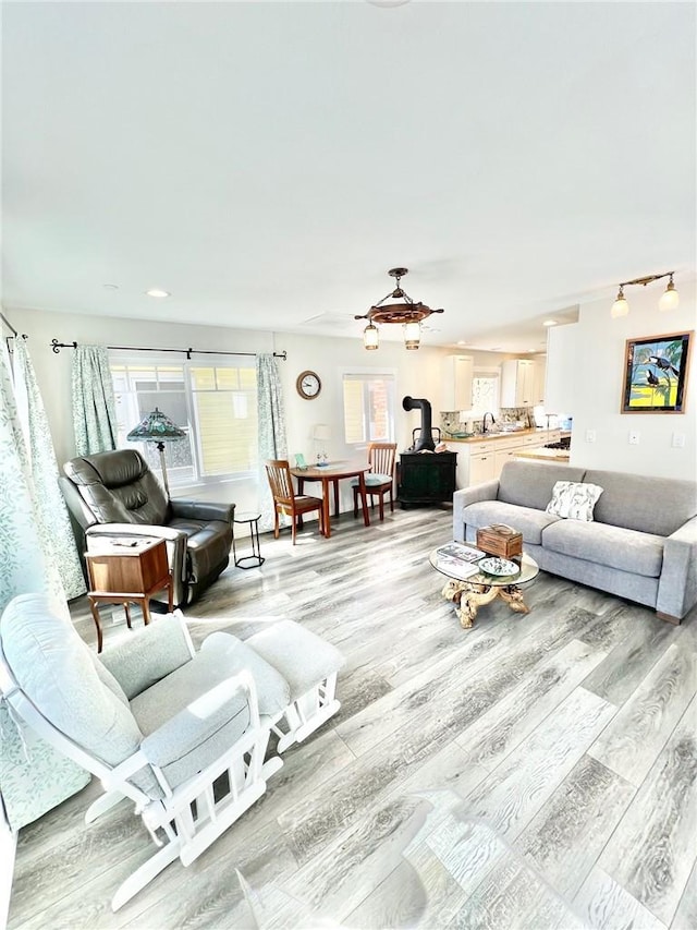 living room with a wood stove and light wood finished floors