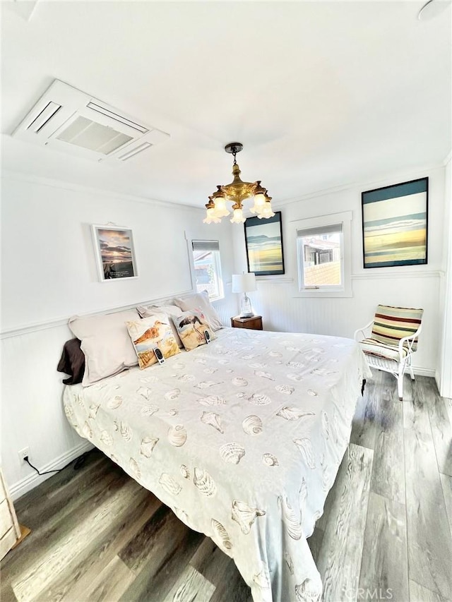 bedroom featuring an inviting chandelier, baseboards, and dark wood-type flooring