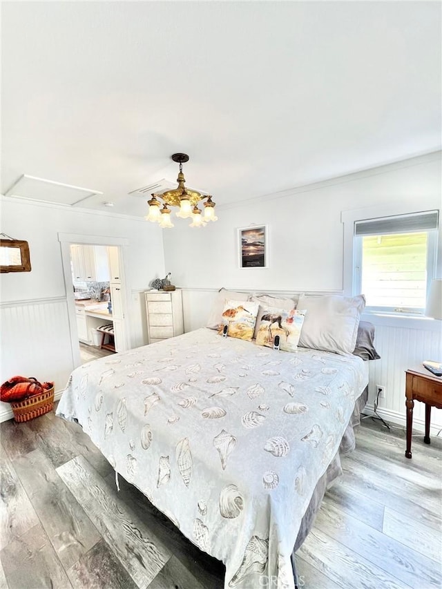 bedroom with a wainscoted wall and wood finished floors