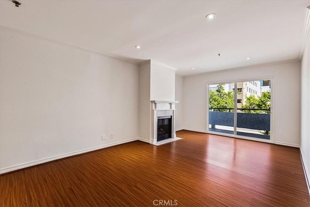 unfurnished living room with recessed lighting, dark wood-style flooring, a fireplace with flush hearth, baseboards, and ornamental molding