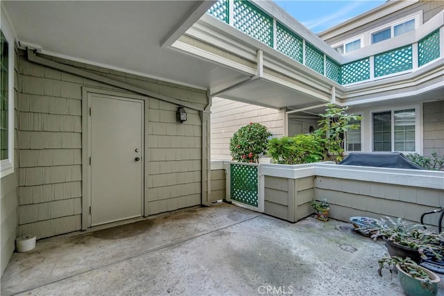 view of exterior entry with a patio area