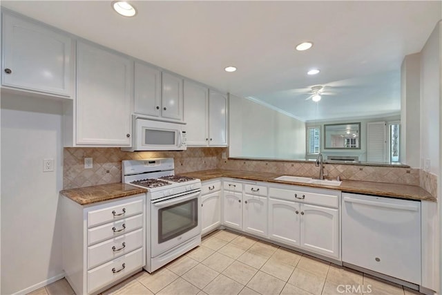 kitchen with white appliances, white cabinets, a sink, and decorative backsplash