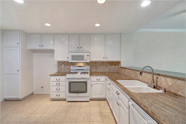 kitchen with light tile patterned floors, tasteful backsplash, white cabinetry, a sink, and white appliances