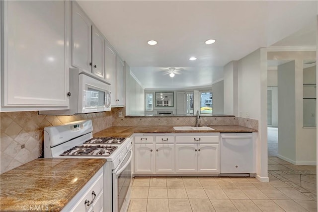 kitchen featuring tasteful backsplash, a ceiling fan, white cabinetry, a sink, and white appliances