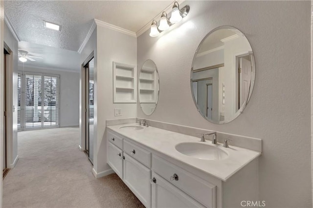 bathroom featuring double vanity, a textured ceiling, ornamental molding, and a sink