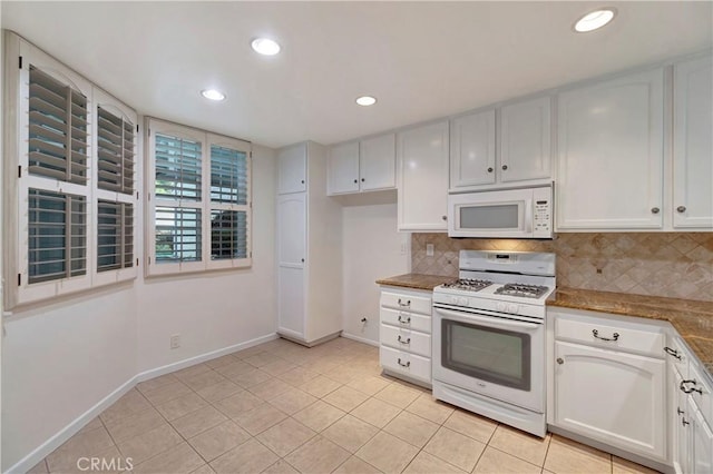 kitchen with light stone counters, light tile patterned flooring, white appliances, white cabinets, and tasteful backsplash