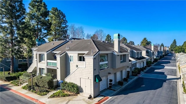 exterior space with central AC, a chimney, an attached garage, and a residential view