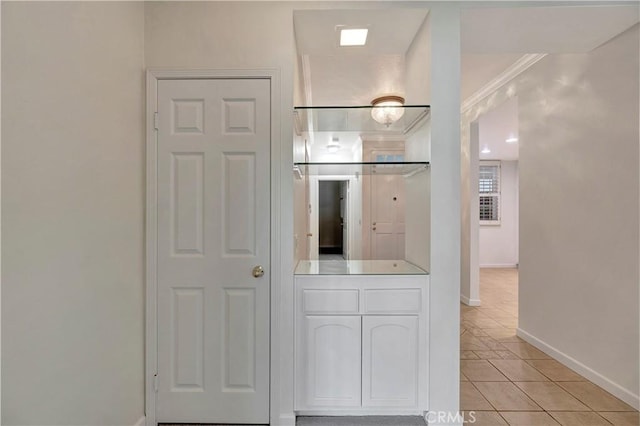 interior space with light tile patterned floors, baseboards, white cabinetry, and light countertops