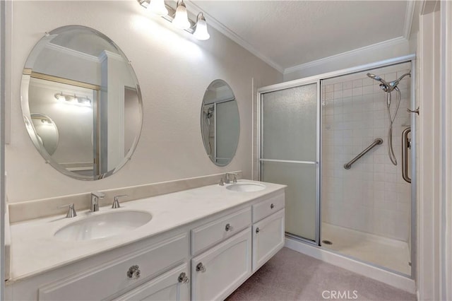 bathroom with double vanity, crown molding, a sink, and a shower stall