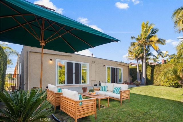 back of property featuring stucco siding, fence, an outdoor living space, and a yard