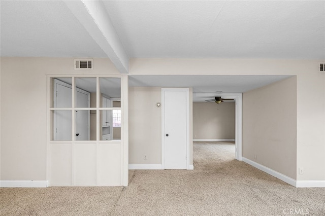 unfurnished room featuring baseboards, beam ceiling, visible vents, and light colored carpet