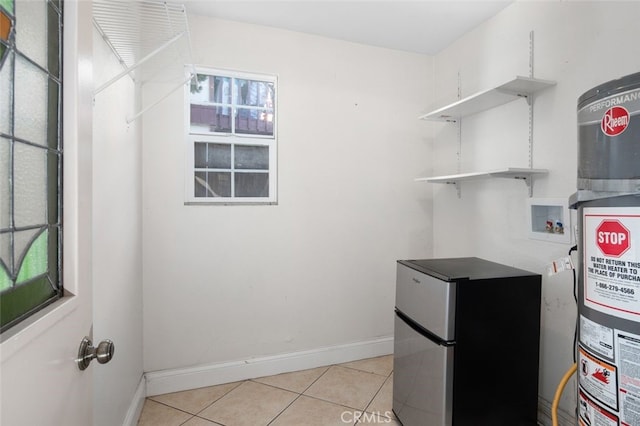 laundry area with washer hookup, secured water heater, light tile patterned flooring, laundry area, and baseboards