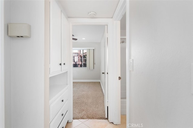 hallway with light tile patterned floors and light colored carpet