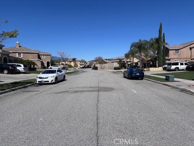 view of road featuring sidewalks, a residential view, and curbs