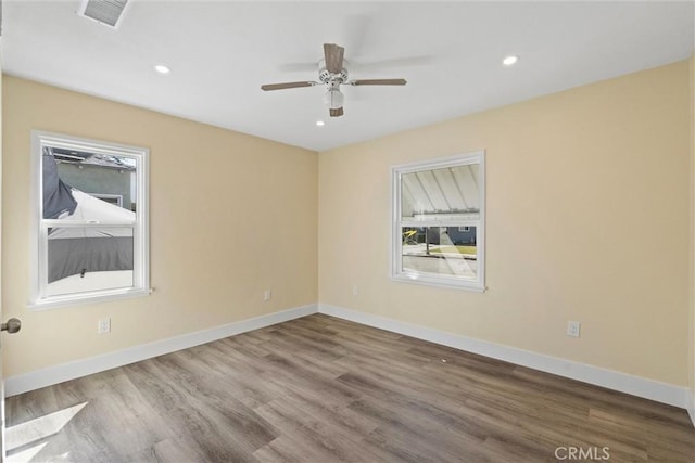 spare room featuring recessed lighting, visible vents, baseboards, and wood finished floors