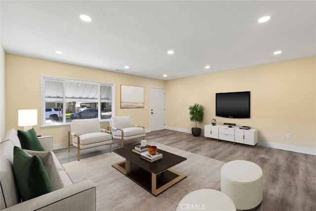 living area with recessed lighting, baseboards, and wood finished floors