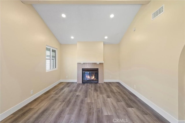 unfurnished living room featuring visible vents, baseboards, a tiled fireplace, recessed lighting, and wood finished floors