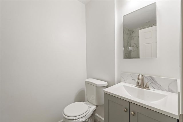 bathroom with vanity, toilet, and baseboards