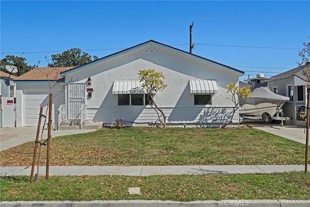 ranch-style home with a front yard, a garage, driveway, and stucco siding