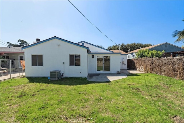 back of property featuring fence, central AC unit, stucco siding, a yard, and a patio area