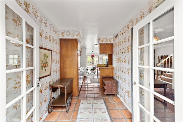 interior space featuring wallpapered walls and crown molding