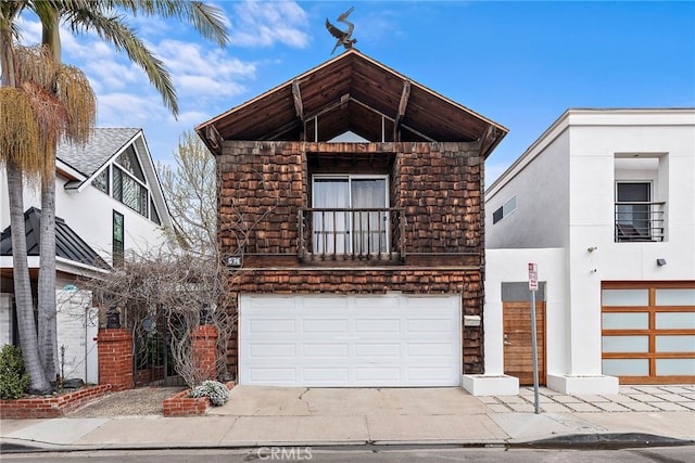 view of front of property featuring a balcony, concrete driveway, and an attached garage
