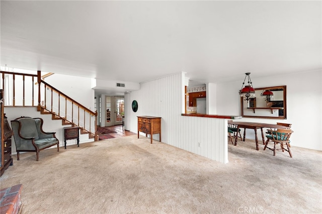 living room with french doors, visible vents, stairway, and carpet